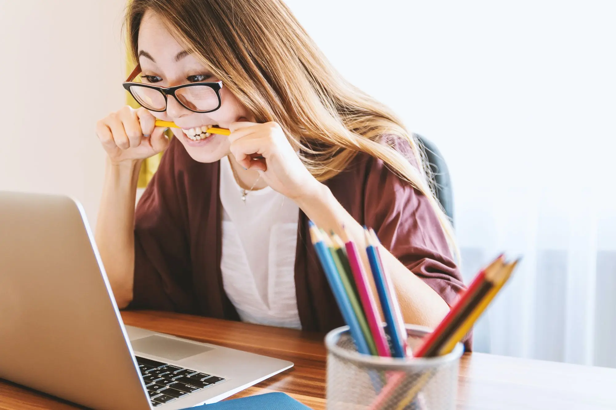 Woman biting a pencil during remote work