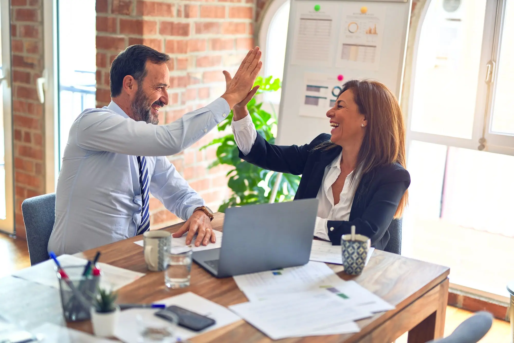 Two employees high five each other