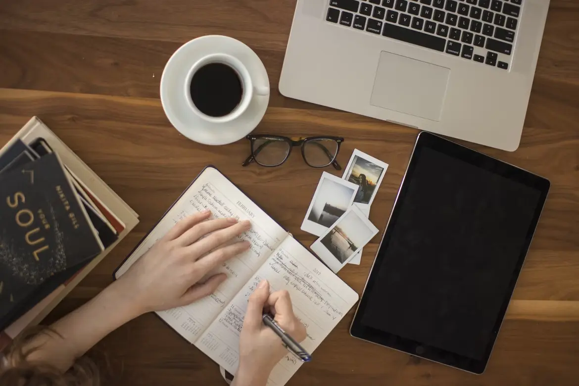 person writing on notebook