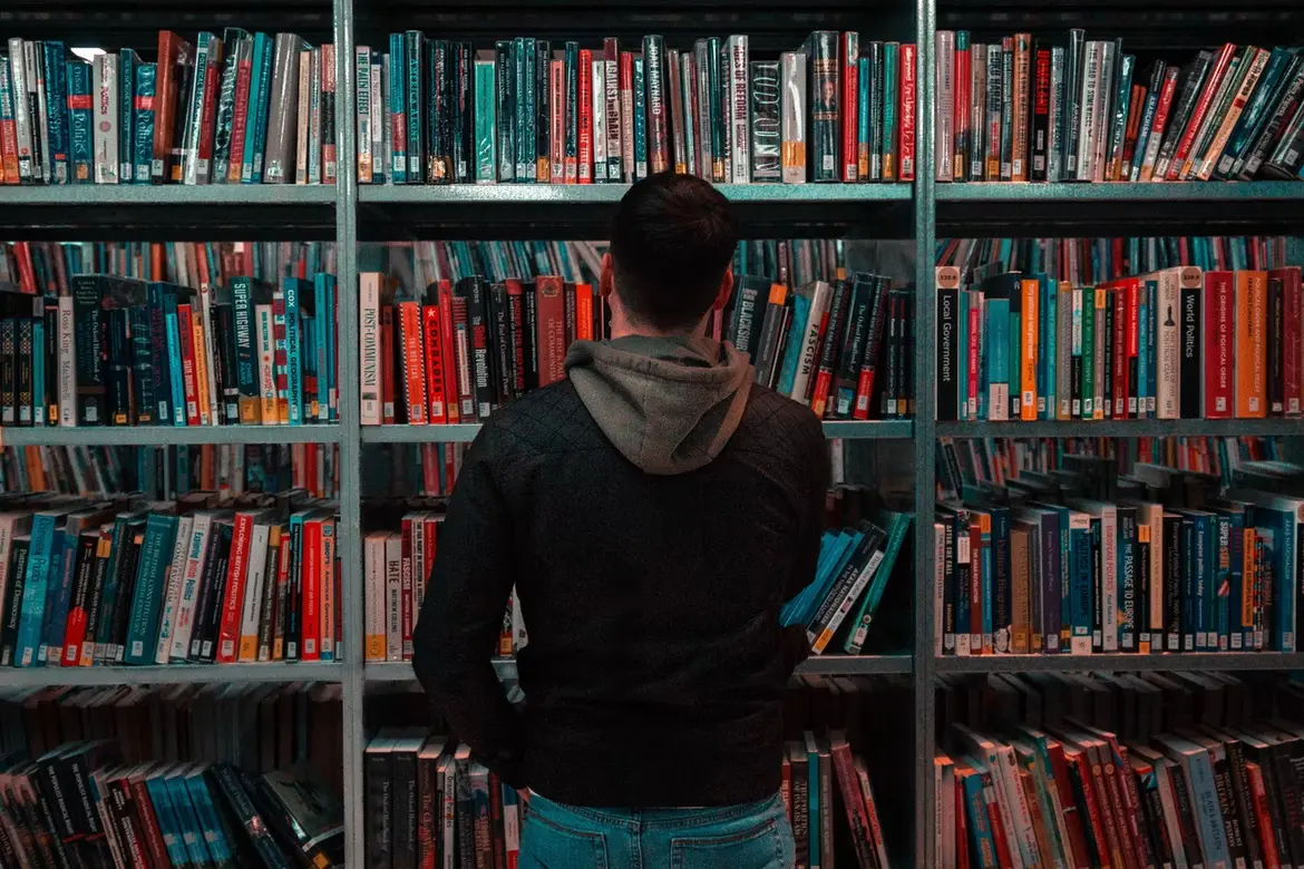person standing in front of a book shelf