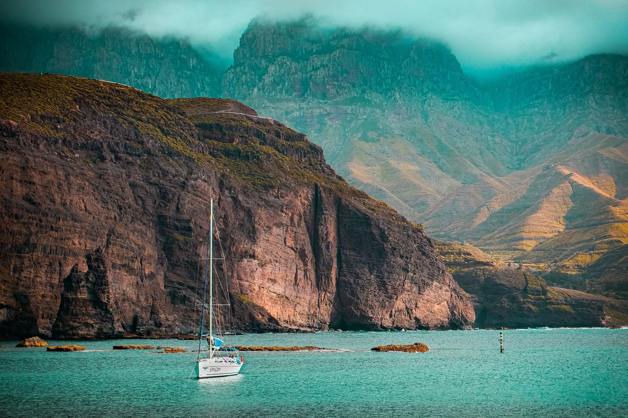White boat on sea near mountains